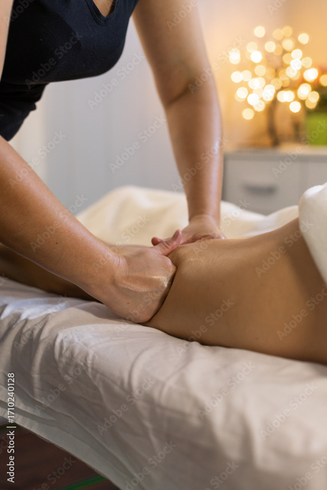 Fototapeta premium Thumbs applying pressure on leg muscles during massage therapy