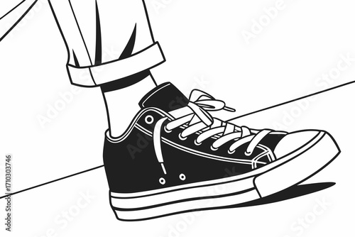 Close up of a person s foot wearing a black high top sneaker with rolled up pants