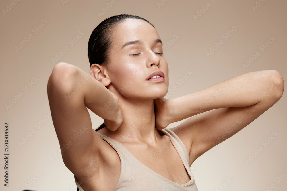 Obraz premium Young woman with closed eyes and relaxed expression, showcasing natural beauty and peacefulness against a soft beige background, ideal for wellness concepts