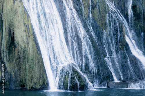 Quadro em tela Majestic multi-tiered waterfall cascading down a vibrant green mossy cliff face