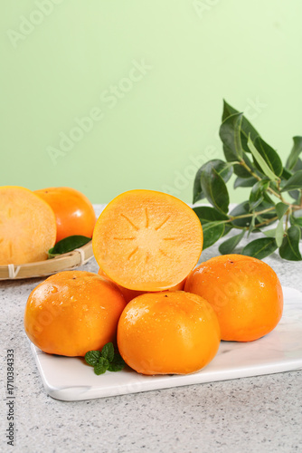 Fresh Sweet Persimmons on Marble Board with Green Leaves - Healthy Organic Fruit Display