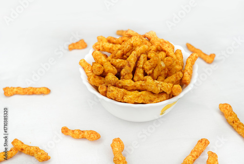 Delicious India favorite snack kurkure crunchy corn sticks, on white background. Indian tea snacks concepts.