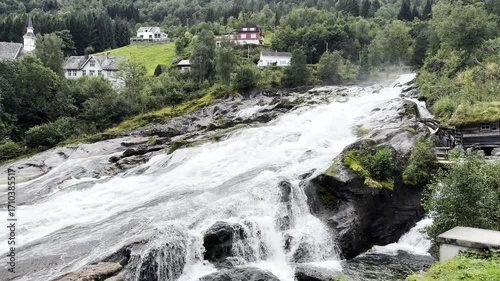 Waterfall in the village of Hellesylt Norway and houses 