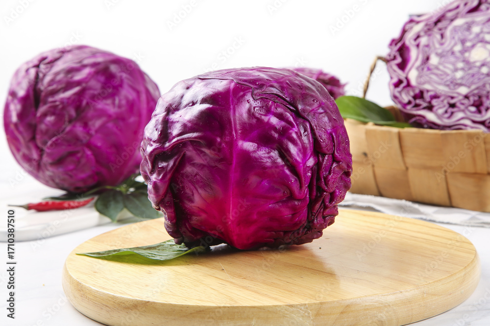 Obraz premium Fresh Purple Red Cabbage Heads on Wooden Cutting Board Kitchen Preparation