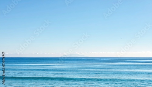 Fototapeta Naklejka Na Ścianę i Meble -  Endless Ocean Horizon with Clear Blue Sky and Distant Land Mass Serene Seascape with Calm Waters in Natural Light Tranquil Scene