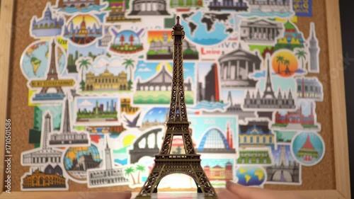 Eiffel Tower miniature on cork board with travel stickers