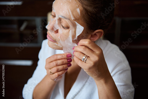 Woman Removing Sheet Mask While Enjoying a Relaxing Skincare Routine at Home