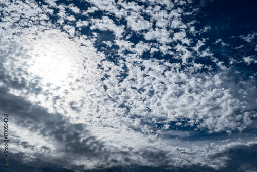 Fluffy white clouds with sun and blue sky