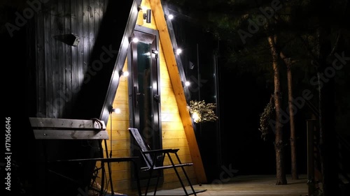 Cozy cabin exterior illuminated by warm lights at night, showcasing wooden textures and inviting ambiance, creating a serene atmosphere for relaxation and connection with nature