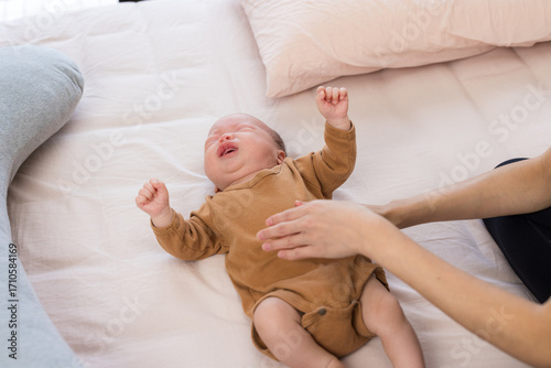 Mum gives tummy massage to baby boy