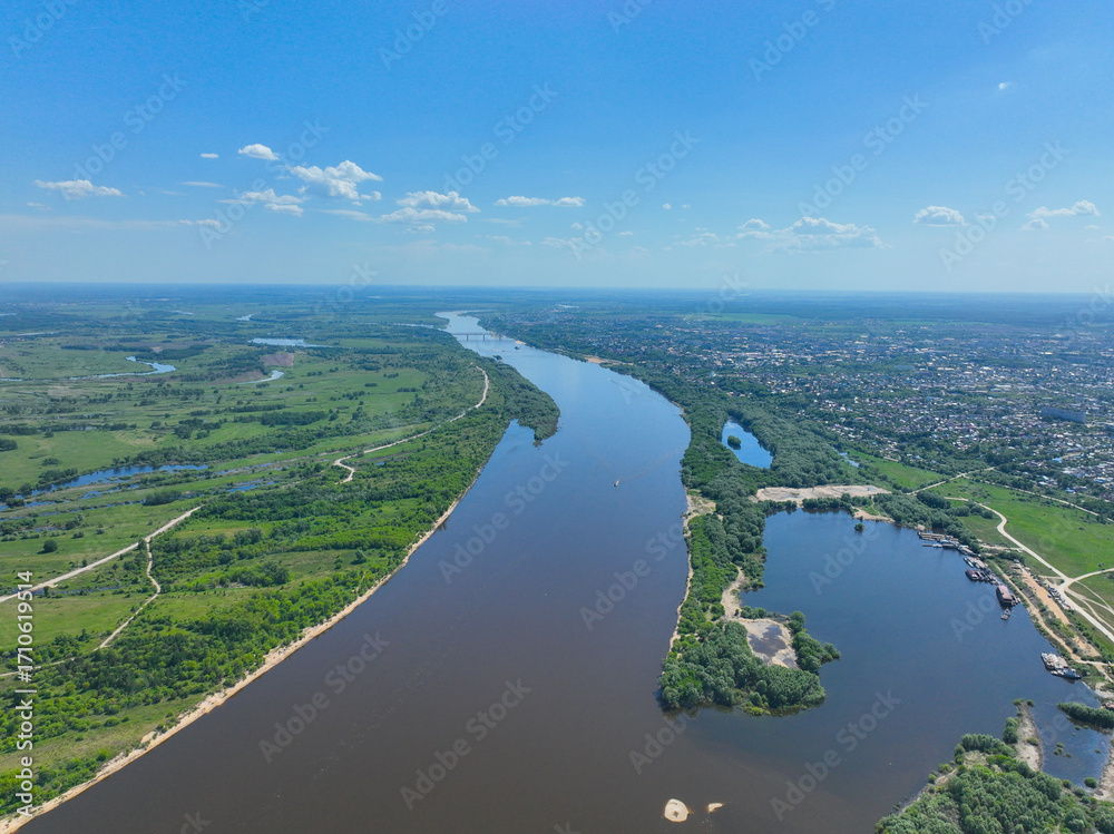 Obraz premium A wide aerial perspective showing the Oka River curving through the green landscape with the cityscape of Murom visible on the right bank.