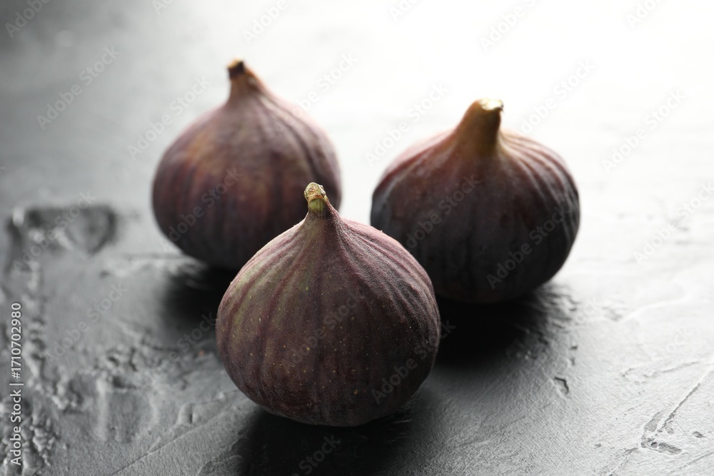 Obraz premium Fresh ripe figs on dark textured table, closeup