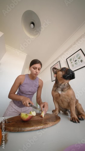 A Woman and Her Dog are Enjoying Delicious Apples Together in a Bright and Colorful Kitchen