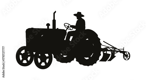 Silhouette of a farmer operating a vintage tractor in a field