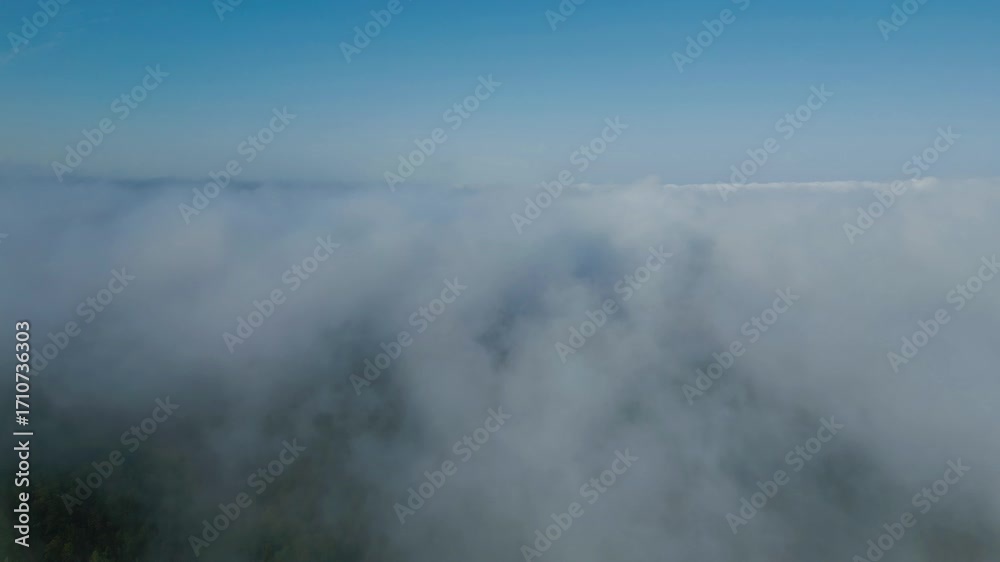 Drone flying forward through dense morning clouds with blue sky Drone flying forward through dense morning clouds with blue sky