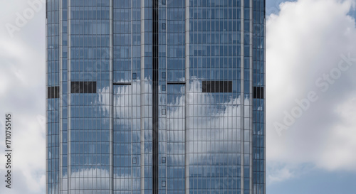 Closeup of Blue Glass Skyscraper Reflecting Clouds Against a Sky