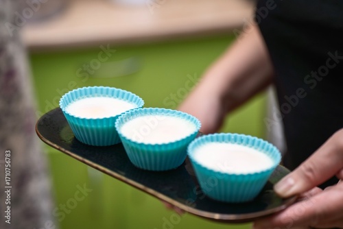 Wallpaper Mural woman carrying an oblong plate with three poached eggs in blue silicone molds Torontodigital.ca