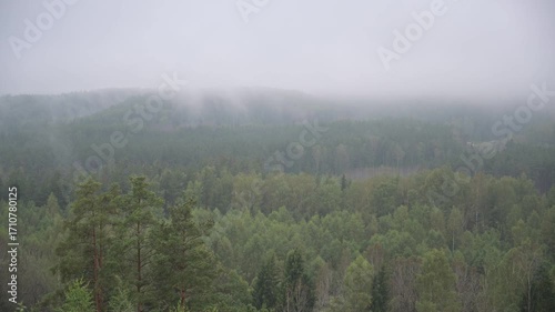 Foggy morning in the high Alps: soft dawn light filtering through misty clouds, solitary mountain peaks, serene and majestic nature atmosphere, perfect for meditative and adventure-themed projects