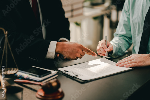 concept of justice and law A male judge in the courtroom on a wooden table and a male counselor or lawyer working in the office. Law, advice and justice concepts.