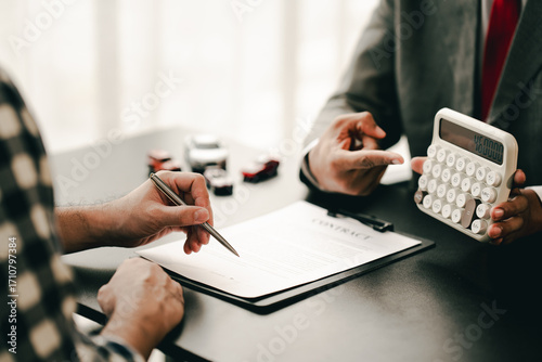 Portrait of a car sales contract signing, a broker advising a client on signing or refinancing a car.