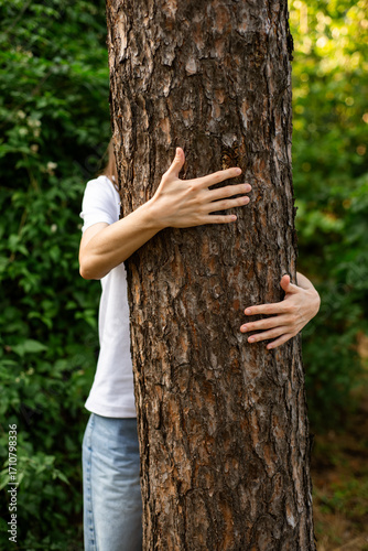 Hands hugging a tree, unity with nature.