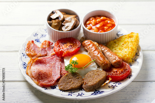 Fotografia Classic traditional Irish or English breakfast with sausages, bacon rashers, whi