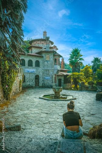 Girl seated in front of Historic Vila Sassetti in Sintra, Portugal