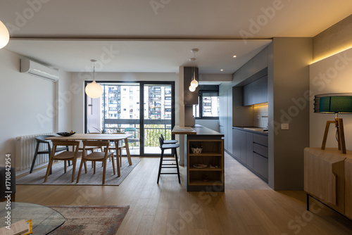 Interior of a modern open-plan kitchen and dining area with city view