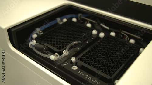 Close-up detailed view of a scientist placing containers into a pipette extraction machine in a laboratory — perfect for themes of precision, automation, science, and laboratory workflow.