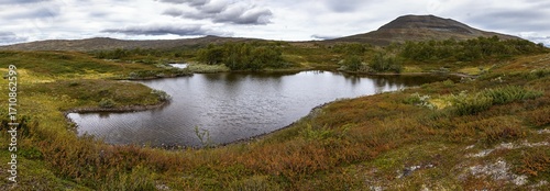 Panoramic view of Getryggen mountain, lake reflection and scenic Swedish wilderness landscape in autumn colors. Between Blåhammaren and Storulvån, Jämtland.
