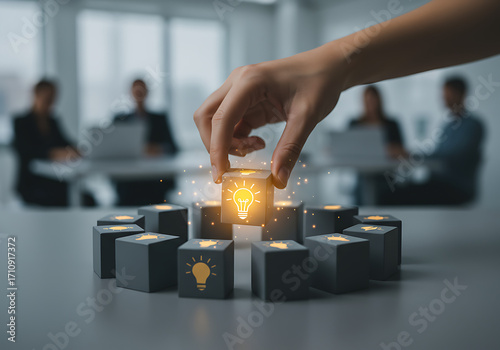 Hand placing a glowing lightbulb icon on a wooden block, symbolizing innovation and new ideas in a business meeting context