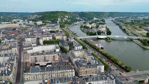 Aerial view of Rouen, France, with the Gothic Rouen Cathedral dominating the skyline, surrounded by historic half-timbered houses, the Seine River, and charming old town streets