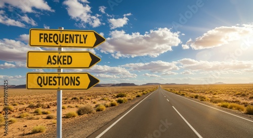 Road sign with arrows pointing to 'Frequently Asked Questions' on a desert highway under a cloudy sky