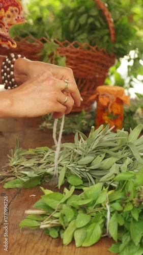 A detailed closeup of hands skillfully tying together fresh and aromatic herbs in a charming rustic kitchen