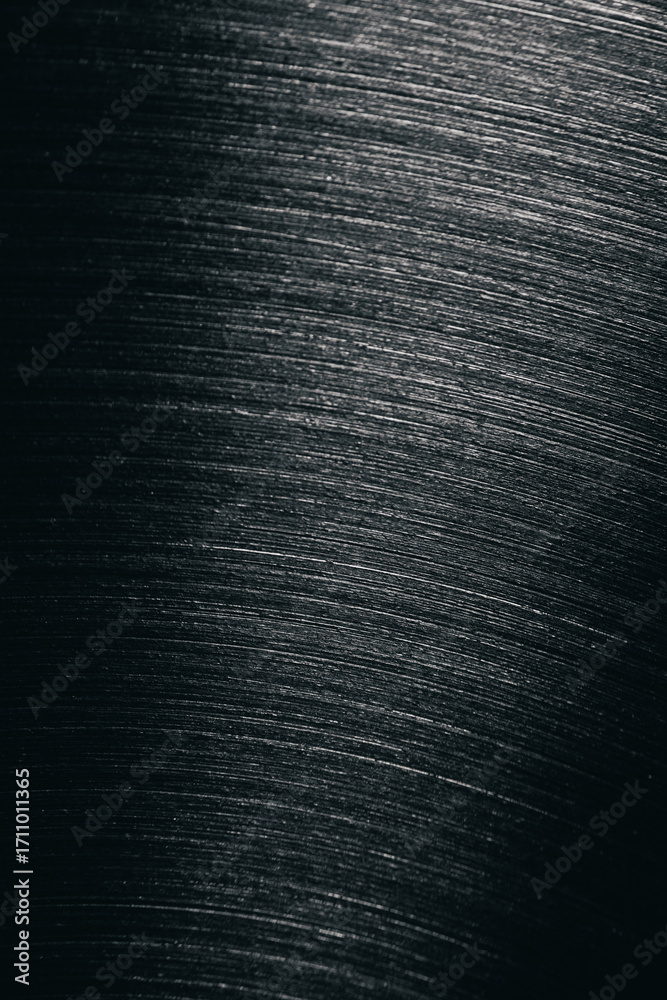 Fototapeta premium Close-up of brushed stainless steel surface showing fine diagonal lines and metallic texture, often seen in cookware, appliances, or industrial materials.