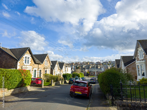 A residential area, in an urban or suburban setting, a mix of housing types and styles, a combination of taller apartment buildings and rows of houses with pitched roofs, a blend of architectural. 
