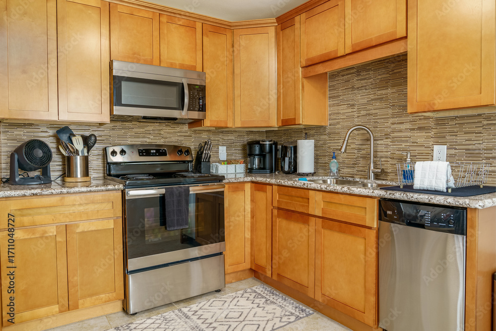 Fototapeta premium Modern kitchen wood cabinets stainless steel appliances