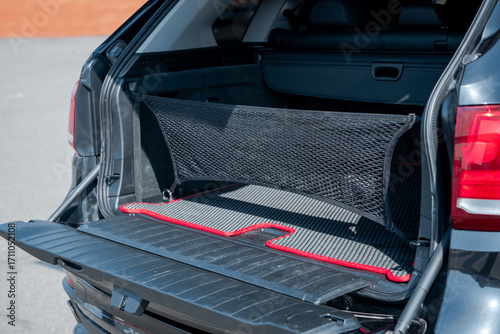 Black SUV with opened trunk hatch. Vehicle cargo space with organizer nets.