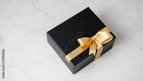 Luxury black gift box with golden ribbon on marble background for greeting cards and banners