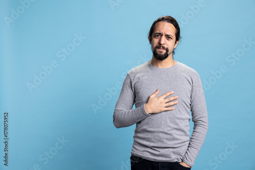 Fotografie Unsure guy in doubt reflecting and contemplating about something in studio, acting uncertain and pondering for decision making