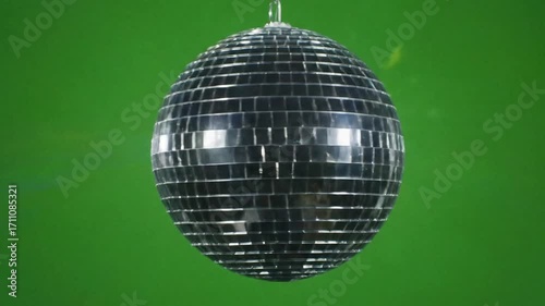This classic glittering mirror ball decoration hangs and spins reflecting bright beams of light on the dancefloor for a vibrant nightclub celebration or a vintage themed disco party