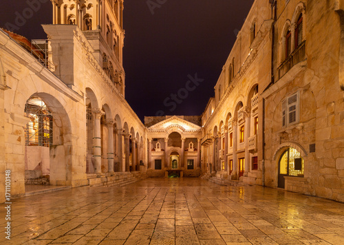 View of the Peristyle courtyard of Diocletian Palace in Split Croatia illuminated at night with historic Roman architecture.