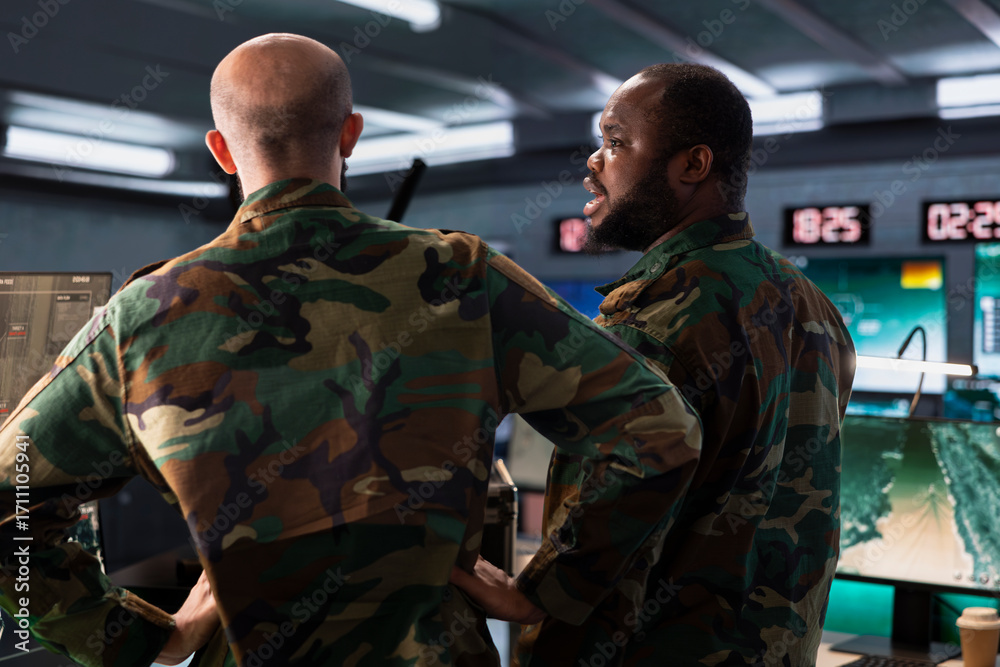 Fototapeta premium Military officer and colleague operating high tech aerial systems to support reconnaissance and target identification. Team of army specialists monitoring counterinsurgency attacks