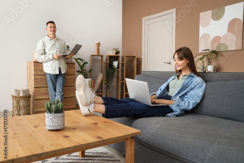 Young couple using laptops ...