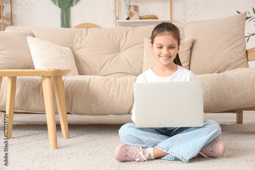 Teenage girl using laptop o...