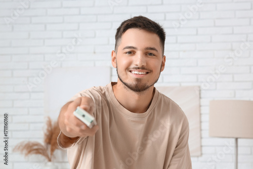 Happy young man turning on ...