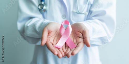 Doctor holding a pink ribbon, symbolizing breast cancer awareness and support, promoting early detection and research for a cure