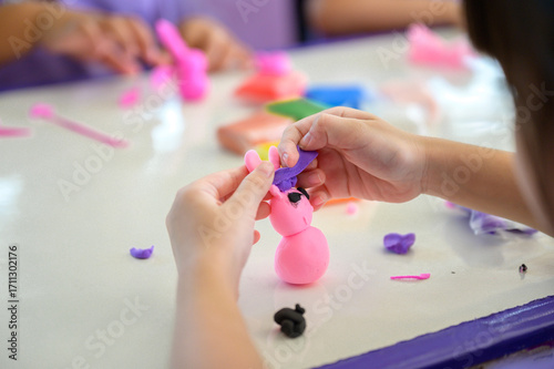 Wallpaper Mural Children making colorful playdough animal figure in classroom, hands shaping creative clay art, preschool education and craft skills, fun learning activity with modeling clay. Torontodigital.ca