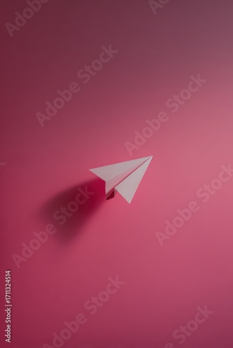Minimalist paper airplane on a gradient rose background. Soft shadow adds dimension to the simple origami art