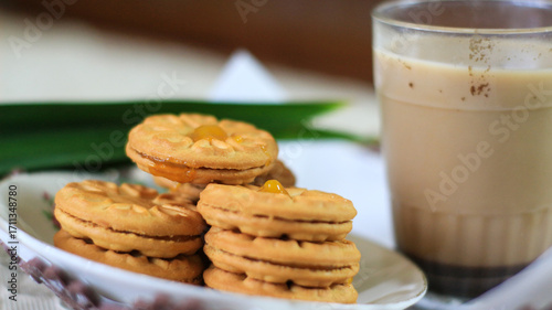 Breakfast and snack menu. Butter biscuits with pineapple jam and a glass of chocolate milk. Close-up of butter cookies and a glass of chocolate, sweet cakes. Perfect for recipes, articles, catalogs.